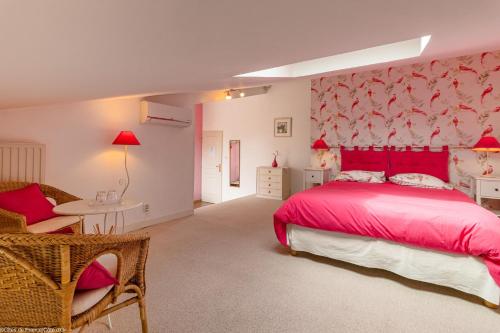 a bedroom with a pink bed and a chair at Les tilleuls in Épernay-sous-Gevrey