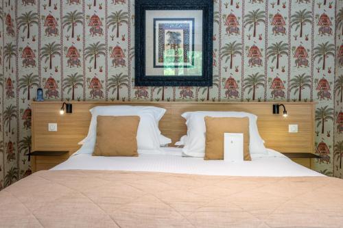 a bedroom with a bed with a picture on the wall at La Chapelle Saint Martin in Nieul