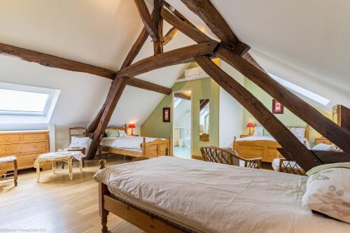 een slaapkamer met een bed in een kamer met balken bij Les tilleuls in Épernay-sous-Gevrey