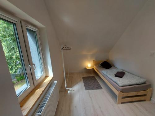 a small room with a bed and a window at Bryziówka B in Miłków
