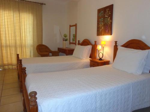 ein Hotelzimmer mit 2 Betten mit weißer Bettwäsche in der Unterkunft Ténis Mar E in Albufeira