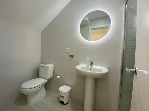 een badkamer met een toilet, een wastafel en een spiegel bij Bahia Meloneras Vista Golf in Meloneras