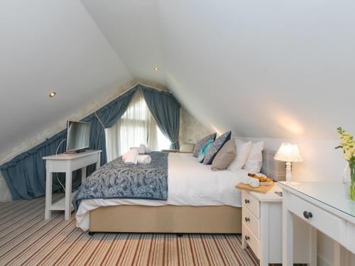 Un dormitorio con una cama grande y una ventana. en Porthminster Penthouse, en St Ives