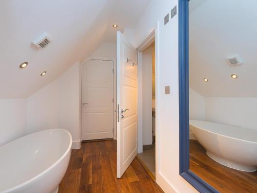 baño con bañera blanca y espejo grande en Porthminster Penthouse, en St Ives