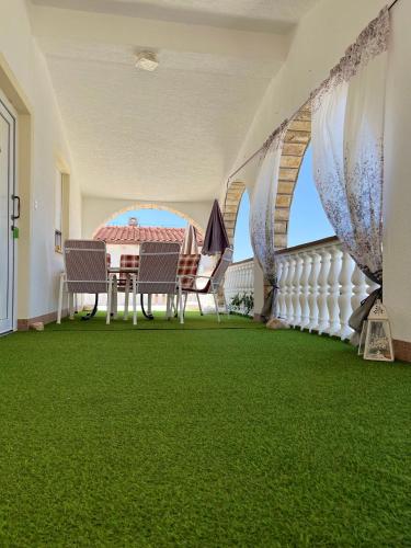 Apartman Tunja في فير: شرفة بطاولة وكراسي على أرضية خضراء