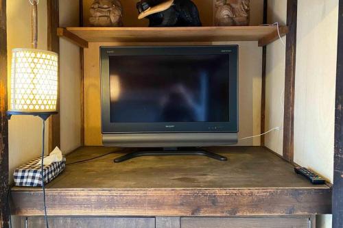 a tv sitting on top of a wooden entertainment center at Konoha house【Japanese-style guest house near Asakusa & Skytree】 in Tokyo