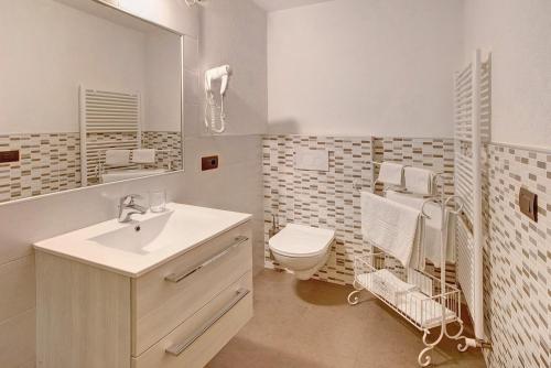 La salle de bains est pourvue d'un lavabo, de toilettes et d'un miroir. dans l'établissement Appartamento Nonna Engadina Chalet, à Livigno