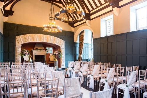 a room with white chairs and tables and chandeliers at HIGHFIELD in Great Driffield