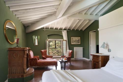 een slaapkamer met groene muren en een bed en een spiegel bij Le Farnete in Carmignano