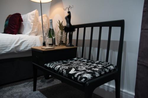 a black chair with a black and white blanket on it at Ideal Lodgings in Accrington in Accrington
