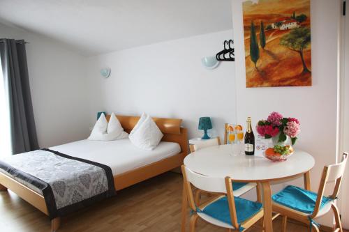 1 dormitorio con 1 cama y 1 mesa con sillas en Apartments Gavric, en Trogir
