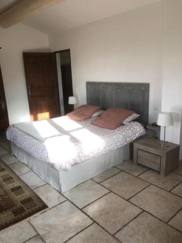 une chambre avec un grand lit et une table de chevet dans l'établissement Mas en Provence, à Arles