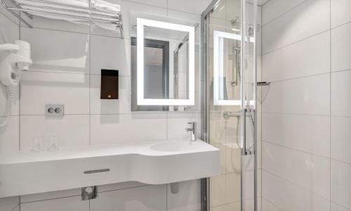 a white bathroom with a sink and a mirror at Thon Hotel Polar in Tromsø