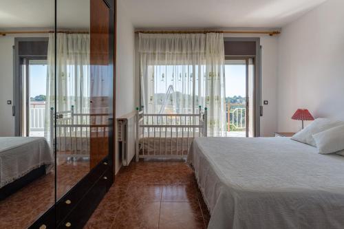 1 dormitorio con 2 camas y ventana grande en Villa Maria, en Lloret de Mar