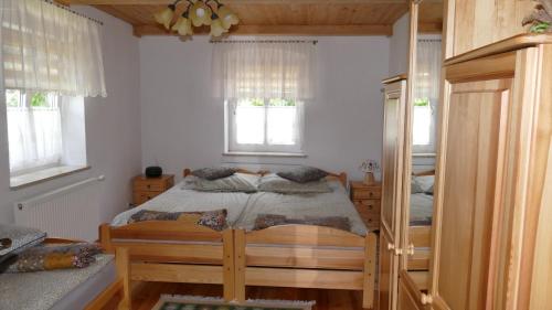 een slaapkamer met een bed en 2 ramen bij Warmińskie Mieszkanko in Biskupiec