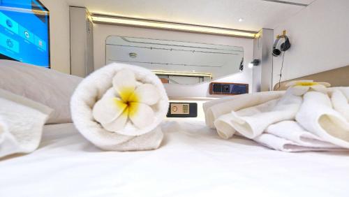 un letto con asciugamani e un fiore sopra di Ljubljana Capsule Hostel a Lubiana