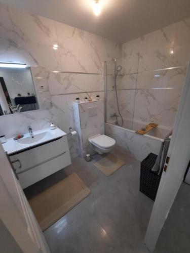 uma casa de banho com um lavatório, um WC e uma banheira em Jacuzzi Appartement love room em Freneuse