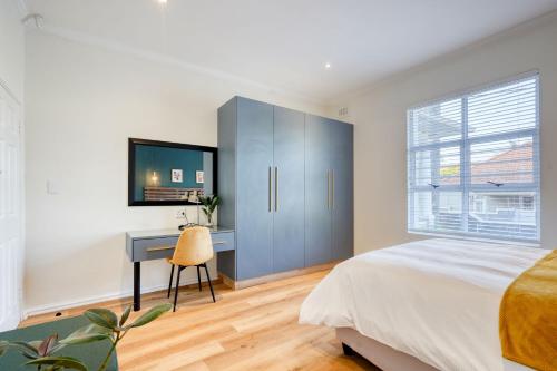 um quarto com uma cama, uma secretária e uma janela em Hampton Collection - Charming 1 or 2 Bedroom Apartment with Pool em Durban