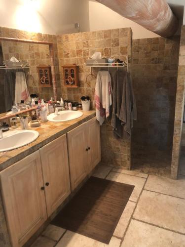une salle de bain avec deux lavabos et deux miroirs dans l'établissement Mas en Provence, à Arles