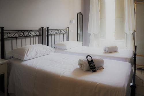 2 camas con sábanas blancas y un par de toallas en Affittacamere ALBA, en Florencia
