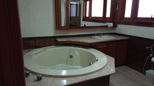 a bathroom with a large tub and two sinks at Casa Portanova Luxe - A 1,5km da Rua Coberta in Gramado