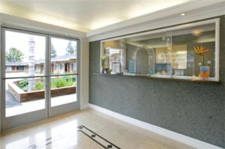 a living room with a large window and a kitchen at Americas Best Value Inn San Bernardino in San Bernardino