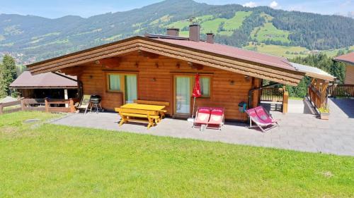 a log cabin with a picnic table and chairs at Berggasthof Staudachstub'n in Kirchberg in Tirol