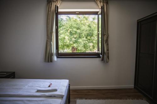 a bedroom with a bed and a window at City-Top Vendégház in Esztergom