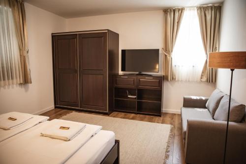 a living room with a couch and a flat screen tv at City-Top Vendégház in Esztergom