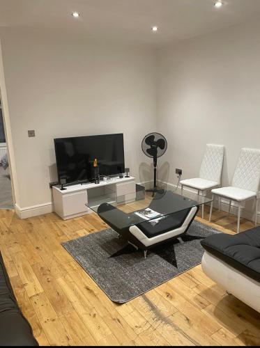 a living room with a couch and a tv at Tee's apartments in Plumstead