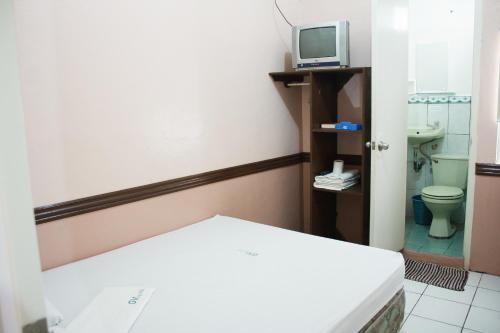 a small room with a bed and a tv at GV Hotel - Catarman in Catarman