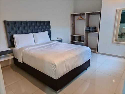 1 dormitorio con 1 cama grande y cabecero negro en MUNAY TTIKA Hoteles, en Moquegua