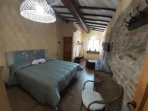 1 dormitorio con cama y pared de piedra en Casale Il Ventaglio, en Ficulle
