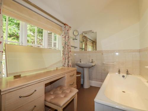 a bathroom with a tub and a sink and a mirror at Vis Valley View in Pentewan