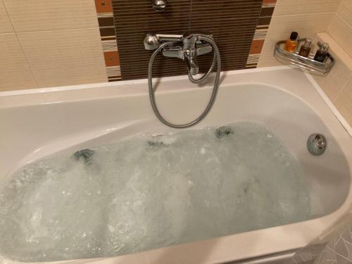 una vasca da bagno piena di acqua di Bright Luxury Apt. a Volos