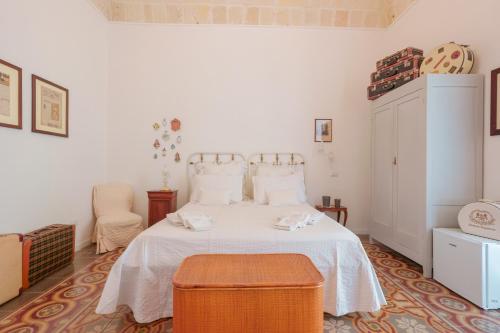 een slaapkamer met een wit bed en een stoel bij B&B Il Melograno Taranto in Taranto