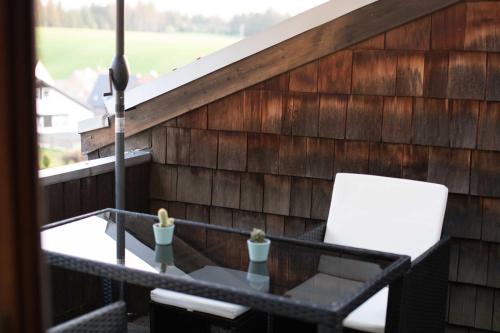 a balcony with a table and a white chair at Auszeit auf 1000 m Höhe mit Familie & Hund in Neukirch