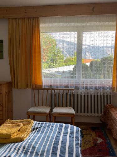 a bedroom with a bed and a large window at Komfortable Ferienwohnung mit herrlicher Aussicht in Sautens