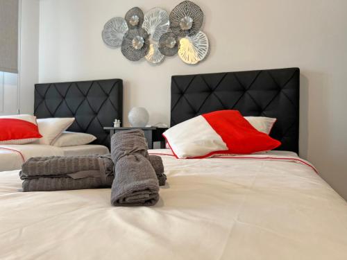 sypialnia z 2 łóżkami i zegarem na ścianie w obiekcie Albert's apartment Center 101 w Larnace