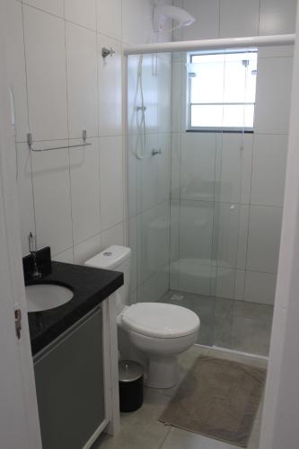 La salle de bains est pourvue de toilettes et d'une douche en verre. dans l'établissement Casatua, à Pomerode