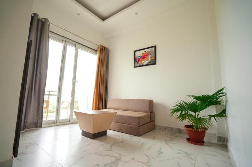 a living room with a couch and a plant at Chirping Hills Resort,Bhimtal in Bhīm Tāl