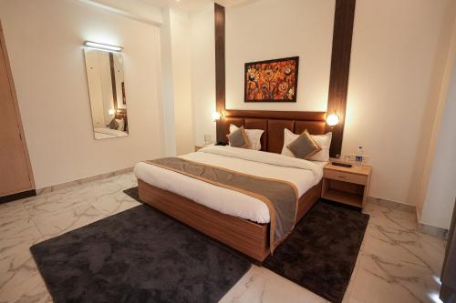 a bedroom with a large bed and a mirror at Chirping Hills Resort,Bhimtal in Bhīm Tāl