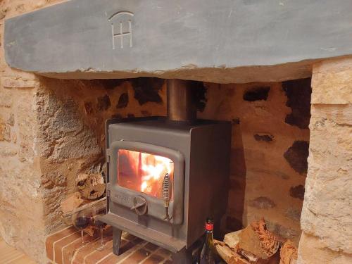 a stone fireplace with a stove in a stone wall at Bungaree Station in Clare