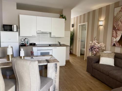 a kitchen and living room with a table and a couch at Luxury Apartment fronte piscina Mareverde A&V Costa Adeje in Adeje