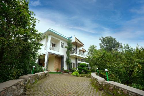 a large white house with a stone driveway at Chirping Hills Resort,Bhimtal in Bhīm Tāl