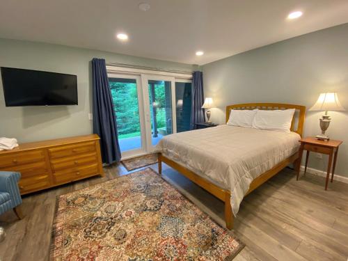 a bedroom with a bed and a flat screen tv at R7 Ski-in Ski-out Bretton Woods Townhome on 2-mile home trail Mt Washington views in Carroll