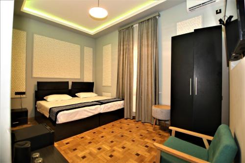 a bedroom with a bed and a chair at La Casa Hotel Yerevan in Yerevan