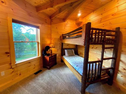 a bedroom with two bunk beds in a log cabin at OR Luxury yurt-like home in Bretton Woods with private beach firepit AC fishing and trails in Carroll