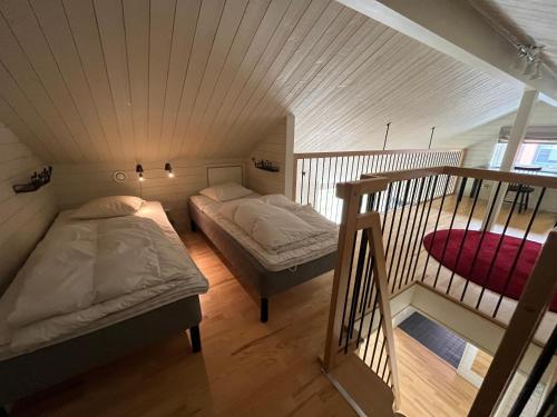 a attic bedroom with two beds and a staircase at Ski Village Funäsdalen in Funäsdalen