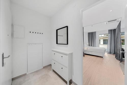 biały pokój z łóżkiem i lustrem w obiekcie VibeStudio 302 - Central - AC - Near Parking w Wiedniu